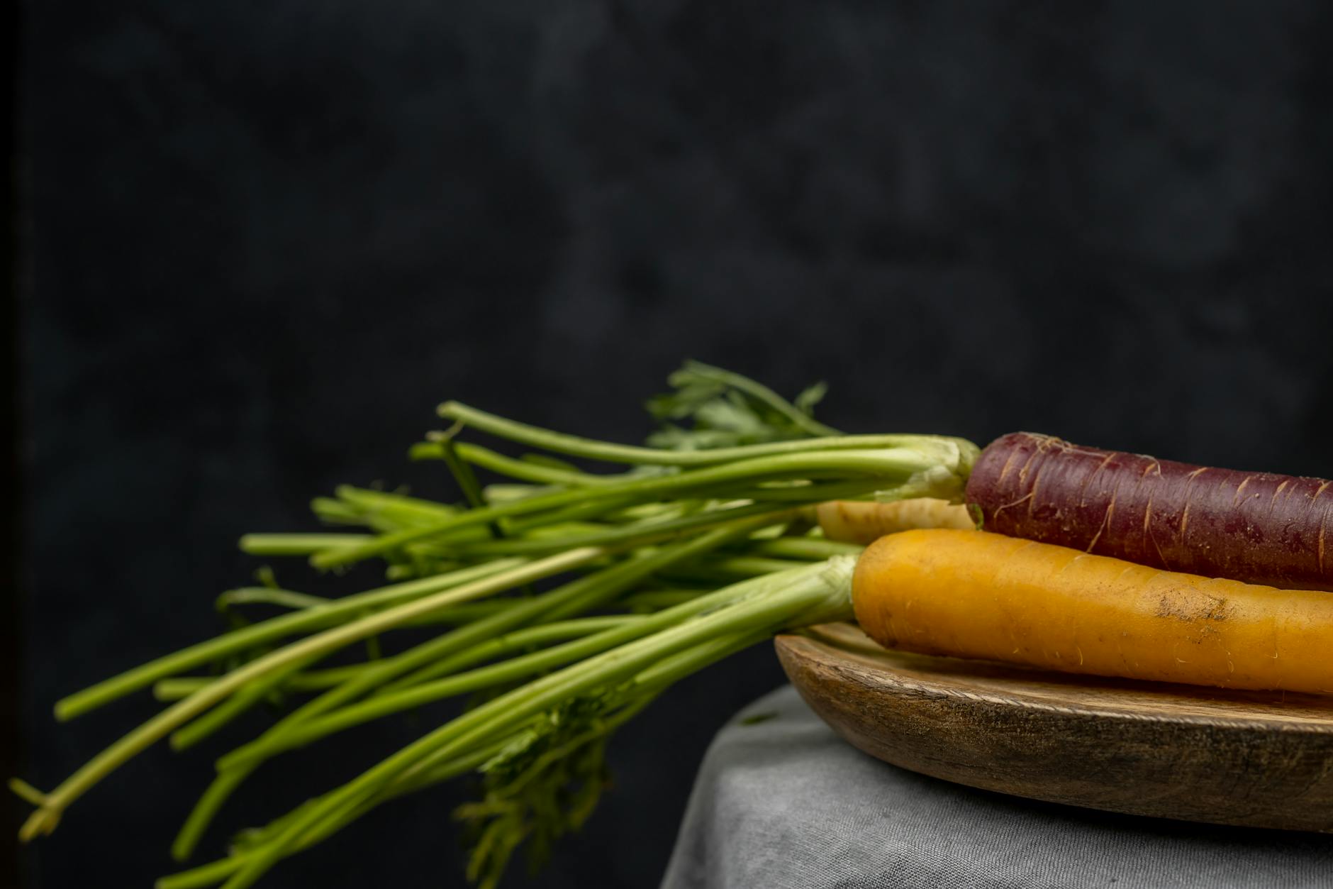 Kolorowe marchewki na drewnianej desce, świeże warzywa dla koni