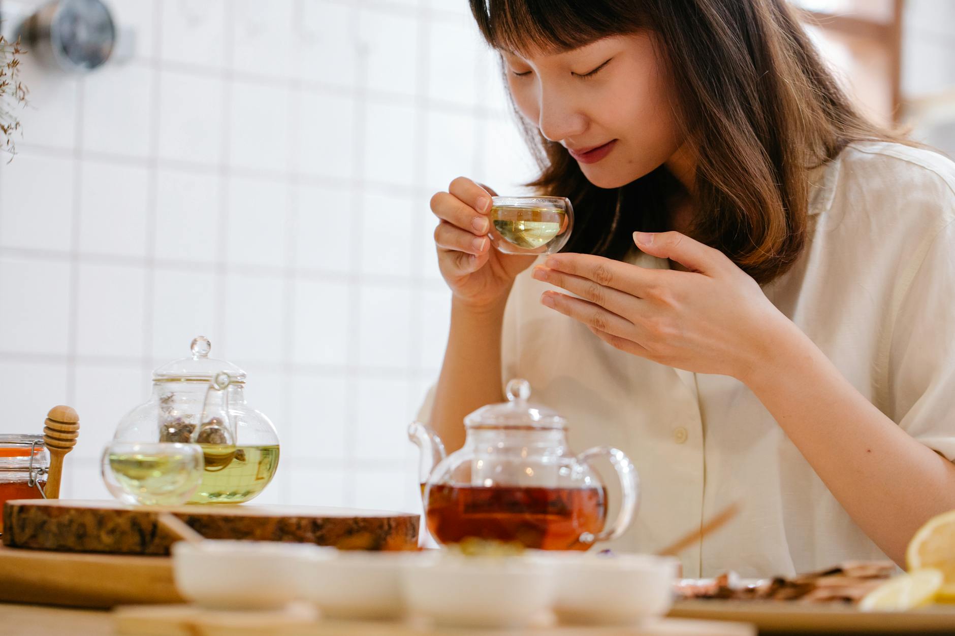Kobieta pijąca aromatyczną herbatę ziołową w przytulnej kuchni