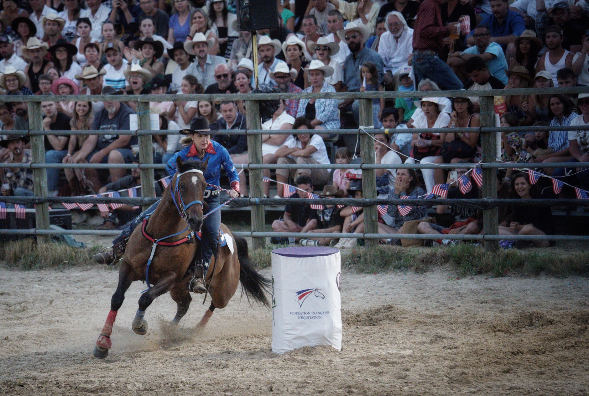 Jeździec na arenie rodeo przed tłumem kibiców