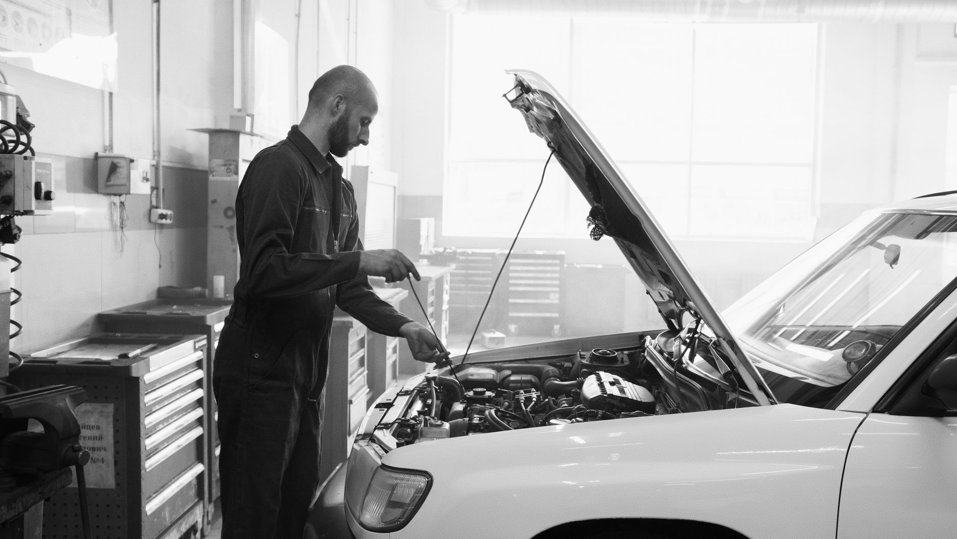 Mechanik w garażu sprawdza silnik samochodu podczas serwisu